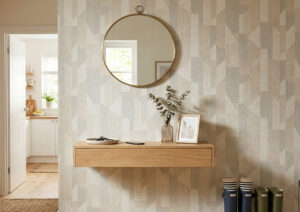 Zdjęcie przedstawia nowoczesny, jasny przedpokój z tapetą w stylowy, geometryczny wzór (beżowo-szary), która buduje klimat i chroni ścianę w tym trudnym komunikacyjnie miejscu.